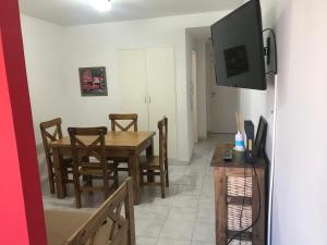 ein Esszimmer mit einem Tisch und Stühlen sowie einem TV in der Unterkunft Departamento Macrocentro in Bahía Blanca