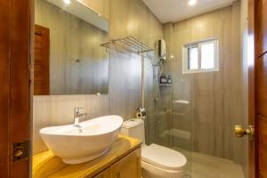 a bathroom with a sink and a toilet and a shower at Dolce Amore Resort in Siquijor