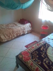 1 dormitorio con 2 camas y alfombra en el suelo en MOCAP, en Kampala