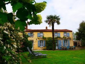 a large yellow house with a palm tree in the yard at La Frapperie in Beaurepaire