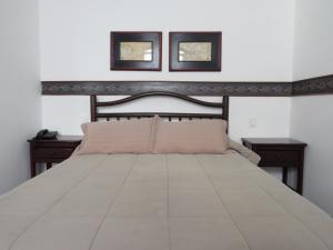 a bedroom with a large bed with two night stands at Hotel Colonial in Ouro Preto