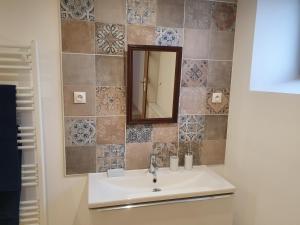 a bathroom with a sink and a mirror at Chez marie poppins in Rozérieulles