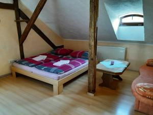 Schlafzimmer mit einem Bett und einem Tisch in der Unterkunft Fewo Am Triebischbrunnen in Meißen