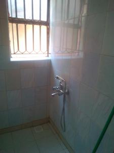 y baño con ducha y ventana. en MOCAP en Kampala