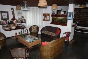 a living room with wicker chairs and a table at Pousada Ogum Marinho in Praia do Forte
