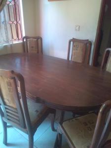 mesa y sillas de madera con mesa de madera y mesa y sillas en MOCAP, en Kampala