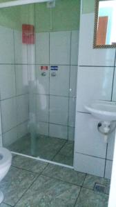 a bathroom with a shower with a toilet and a sink at Pousada Brisas de Setiba in Guarapari