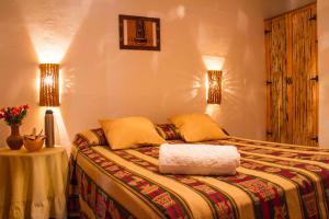 1 dormitorio con 1 cama con 2 lámparas y 1 mesa en Cabañas Tilcara Mia en Tilcara