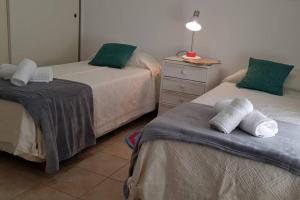 1 Schlafzimmer mit 2 Betten mit grünen Kissen und einer Kommode in der Unterkunft Alquiler Temporario Junin in Junín