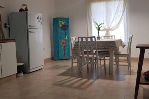 eine Küche mit einem Tisch und Stühlen sowie einem Kühlschrank in der Unterkunft Alquiler Temporario Junin in Junín