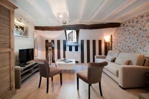 a living room with a couch and a table and chairs at Vign 'Appart in Nuits-Saint-Georges