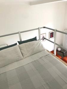 1 dormitorio con 1 cama grande con sábanas blancas en Secret garden in the heart of Isola, en Milán