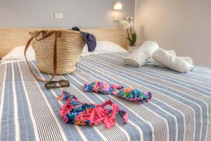 um par de sapatos e toalhas numa cama em Hotel Nautico em Cattolica