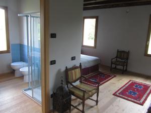 1 dormitorio con cama, silla y aseo en Fara1911 en Fonte
