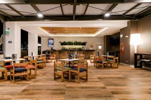 a restaurant with tables and chairs and a bar at Wyndham Costa del Sol Tumbes in Tumbes