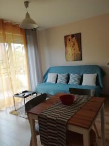 a living room with a blue couch and a table at Residences les roseaux in Lognes