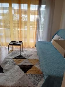 a bedroom with a bed and a table in front of a window at Residences les roseaux in Lognes