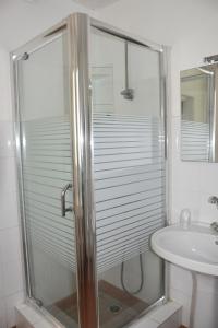La salle de bains est pourvue d'une douche en verre et d'un lavabo. dans l'établissement Hostellerie des châteaux, à Saint-François