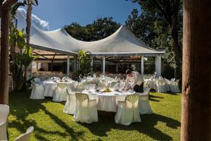 a man standing in front of a marquee with tables and chairs at Hotel Continental Ischia in Ischia