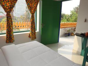 a bedroom with a bed and two windows with curtains at Coral Country Homestay in Agra