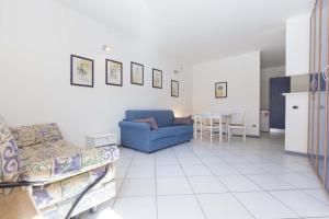 salon z niebieską kanapą i stołem w obiekcie Monolocale il Porto n. 4 w mieście Porto Azzurro +6 zdjęć