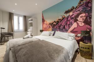 a bedroom with a bed and a painting of a woman at La Torre Boutique Apartamentos in Teruel