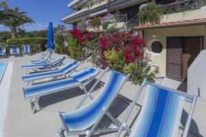 rząd niebieskich leżaków na patio w obiekcie Monolocale il Porto n. 4 w mieście Porto Azzurro