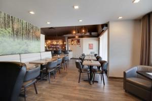 a dining room with wooden tables and chairs at Hôtel Le Voyageur in Sept-Îles