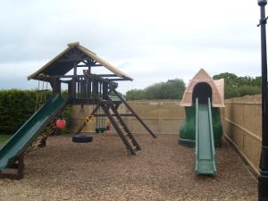 a playground with a slide and a play structure at Herston Caravan & Camping in Swanage
