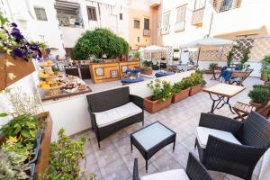 un patio al aire libre con sillas, mesas y plantas en Residence Garibaldi en Trapani
