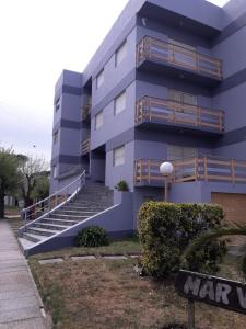 un edificio azul con escaleras delante en Edificio Familiar Mar Veo en Villa Gesell