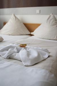 a white bed with a white towel on it at Hotel Zum Wersehof in Ahlen