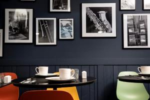 a dining room with two tables and pictures on the wall at Hôtel Hélios Opéra in Paris