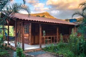 a wooden cabin with a mountain in the background at Casinha de Madeira no Vale do Capão in Vale do Capao +13 photos