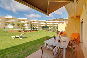 a patio with a table and chairs and a lawn at Albufeira Paradise with Pool by Homing in Albufeira