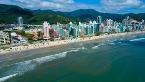 an aerial view of a beach with people and buildings at Apartamento Frente Mar Itapema in Itapema