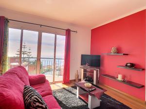 een rode woonkamer met een bank en een tv bij Cliff Refuge by LovelyStay in Santa Cruz