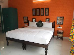 a large bed in a room with an orange wall at Coral Country Homestay in Agra