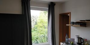 una ventana con vistas a un árbol en TH Exclusive en Düsseldorf