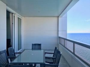 una mesa y sillas en un balcón con vistas al océano en Gemelos 28 Blueline, en Benidorm