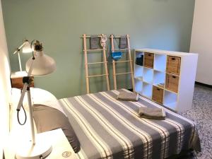 ein Schlafzimmer mit einem Bett mit einer Lampe und Regalen in der Unterkunft Appartamento Madeleine in Levanto