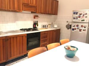 eine Küche mit einer Theke, einem Kühlschrank und einem Tisch in der Unterkunft Appartamento Madeleine in Levanto