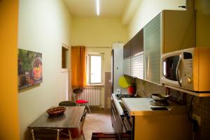 a small kitchen with a table and a microwave at Casa Primavera in Palermo