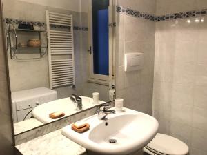 ein weißes Bad mit einem Waschbecken und einem WC in der Unterkunft Appartamento Madeleine in Levanto