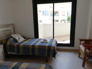 a small bedroom with a bed and a window at Terrazas de las Marinas in Denia