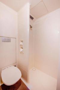a white bathroom with a toilet and a shower at ibis Budget - Campbelltown in Campbelltown