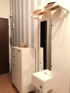 ein Badezimmer mit einem Spiegel und einem weißen Kühlschrank in der Unterkunft Appartamento Madeleine in Levanto