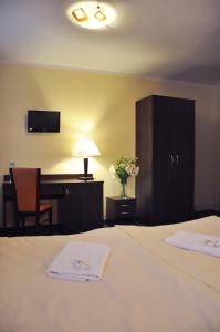 a hotel room with a bed and a desk and a table at Hotel Pojezierze in Szczecinek