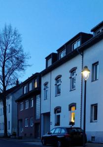 un coche estacionado al lado de un edificio blanco con luz de la calle en TH Exclusive en Düsseldorf