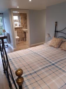 a large bed in a bedroom with a bathroom at Woodlands Cottage Farm in Wickham